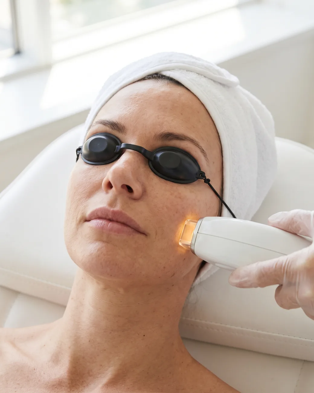 Provider treating a woman's face with the Lumecca IPL handpiece